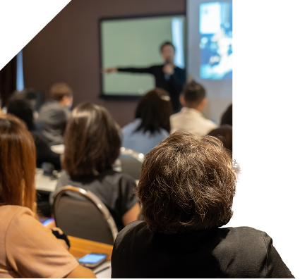 A group of adults looking at a presenter at the front of the room
