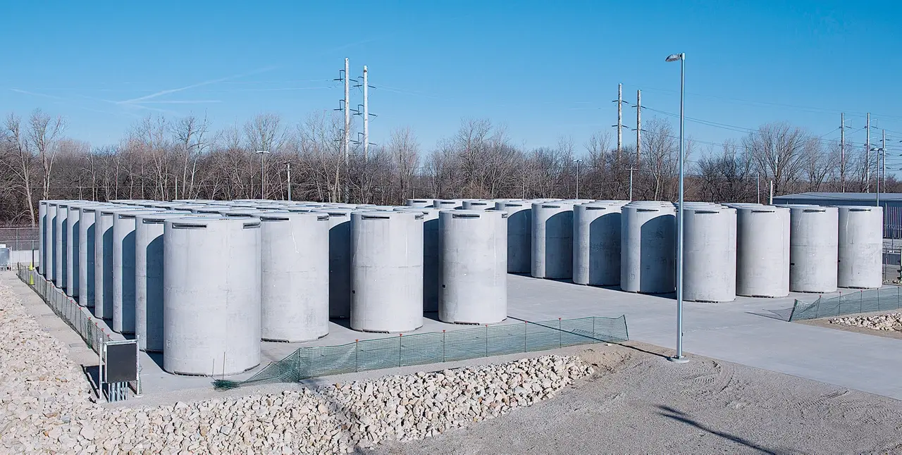 Large group of cement barrels on a cement pad in a remote, empty location